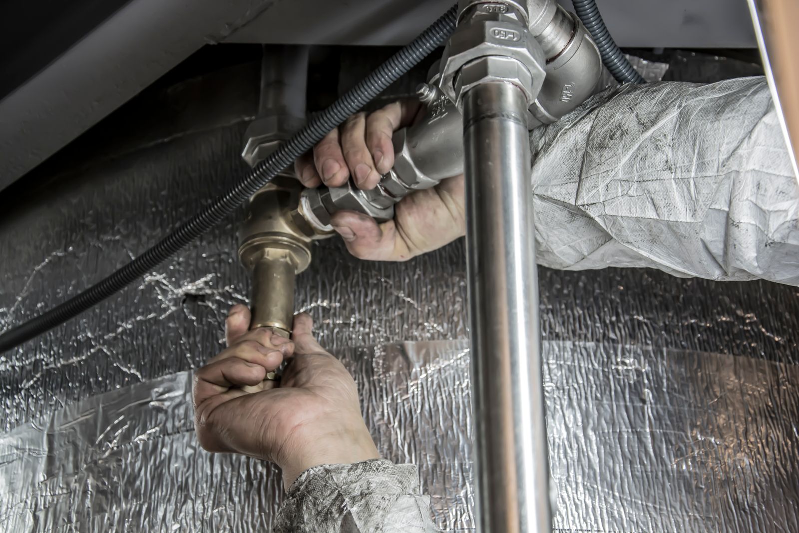 Pipe fittings in an insulated run — the kind of line we camera or open after a recording.